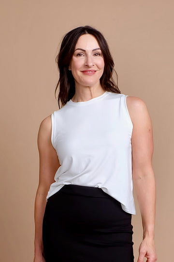 woman wearing white work tank top with black work skirt