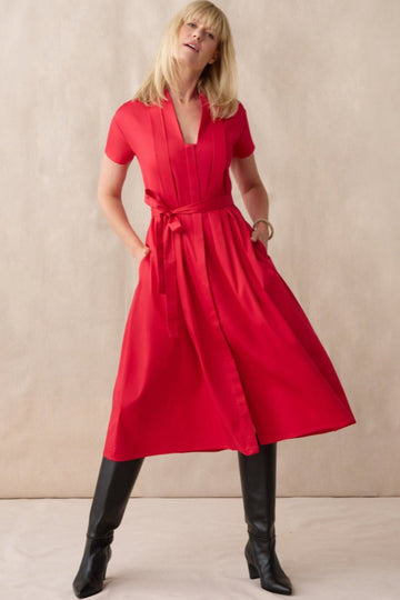 Woman wearing a red dress with a beige background