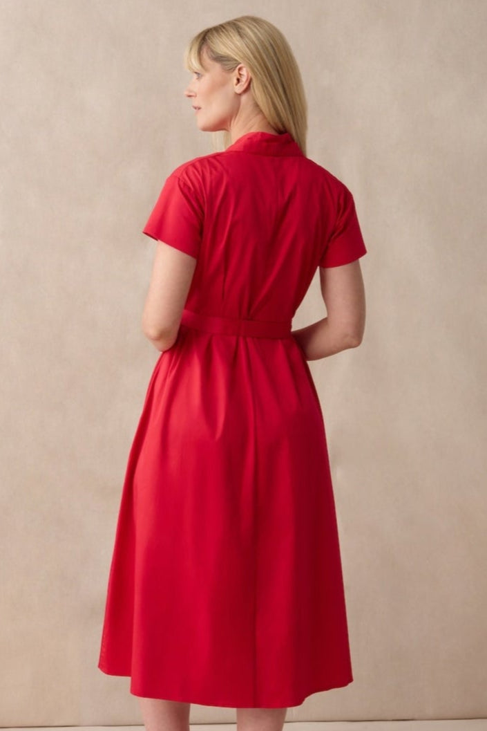 Woman wearing a red dress against a beige background