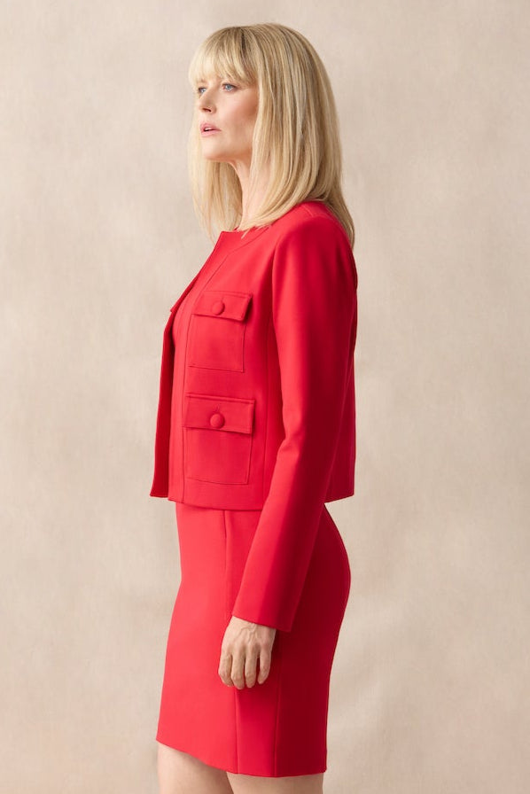 Woman wearing a red outfit standing against a beige background