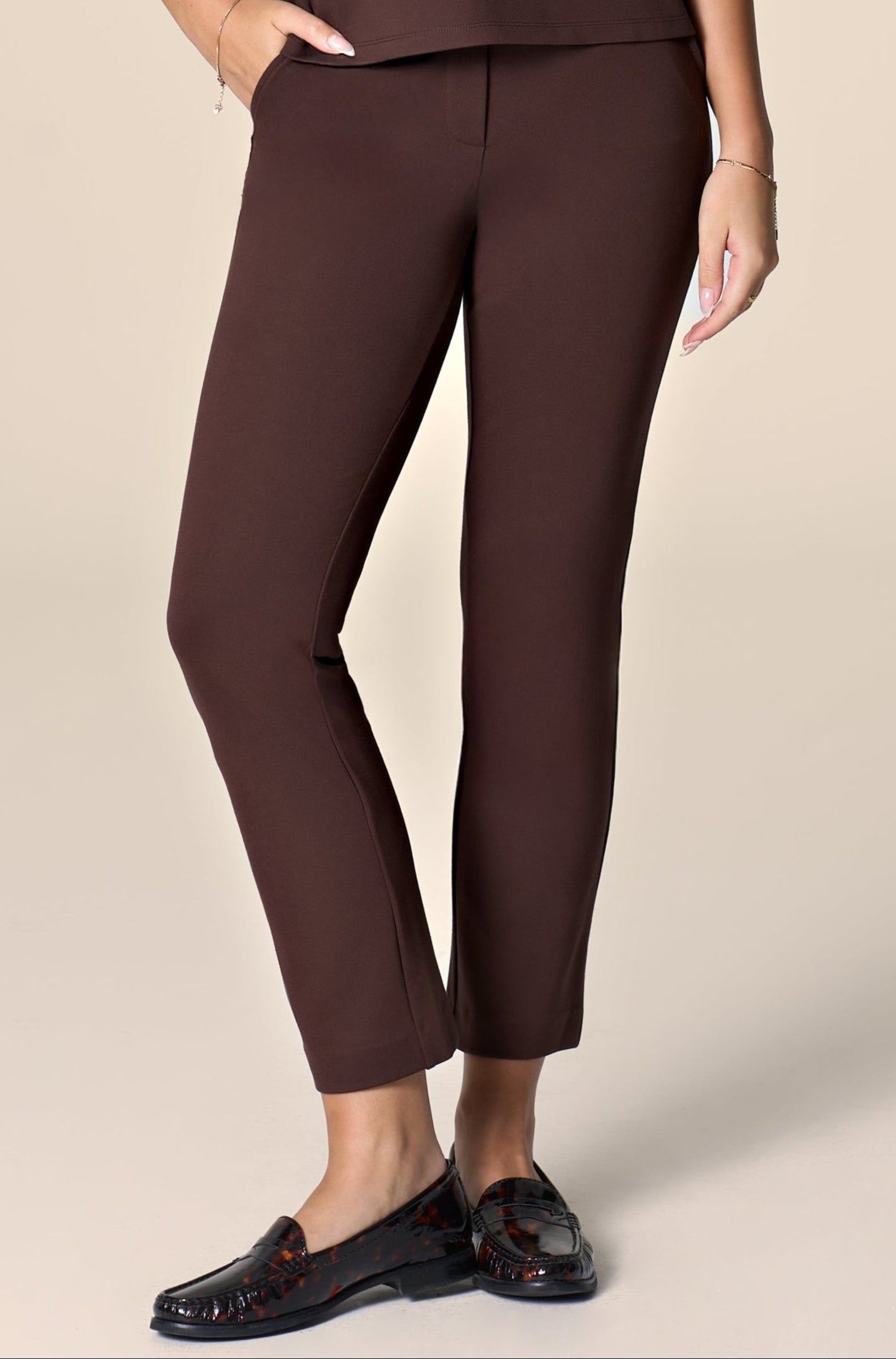 Woman wearing brown monochromatic work outfit on clean background.