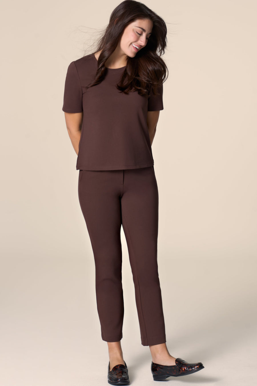 Woman wearing a brown outfit on a beige background