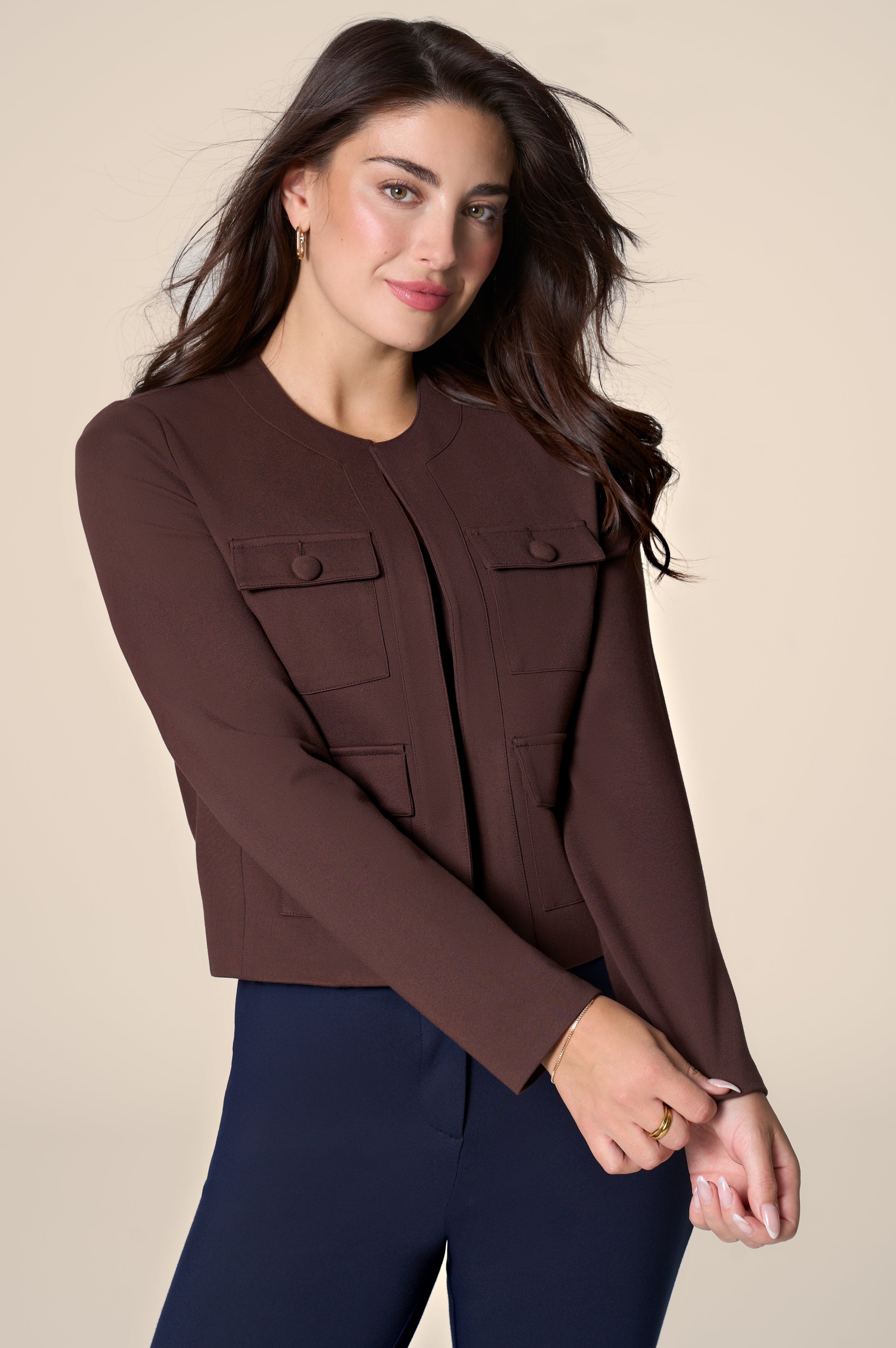Woman wearing brown jacket on white background.