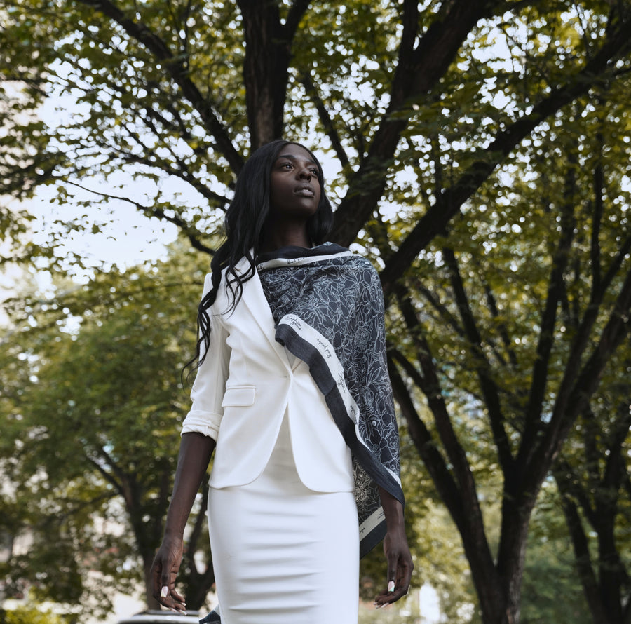woman wearing white work outfit with black scarf
