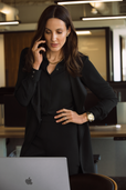 woman on the phone wearing black work outfit