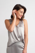 woman wearing sleeveless silver silk work top
