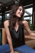 woman wearing sleeveless black silk top with jeans