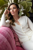 woman sitting wearing ivory button up sweater